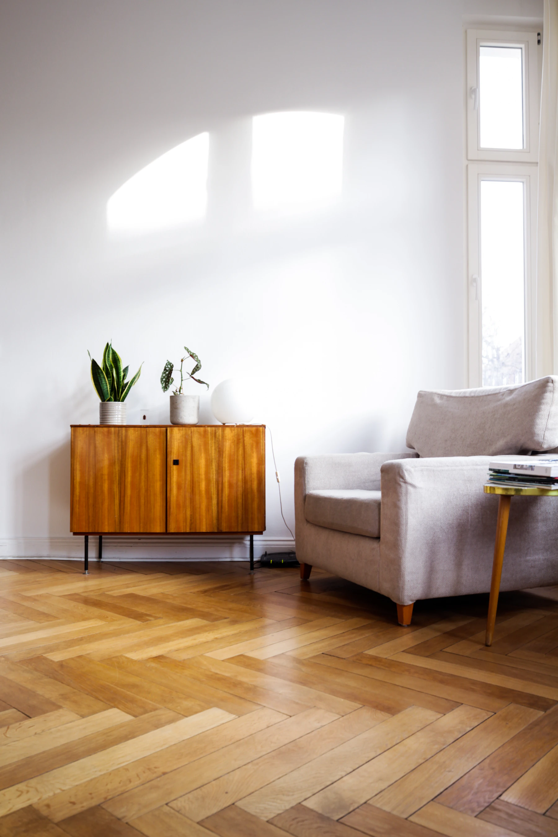 Lumière naturelle sur un mur clair et un buffet en bois dans un salon