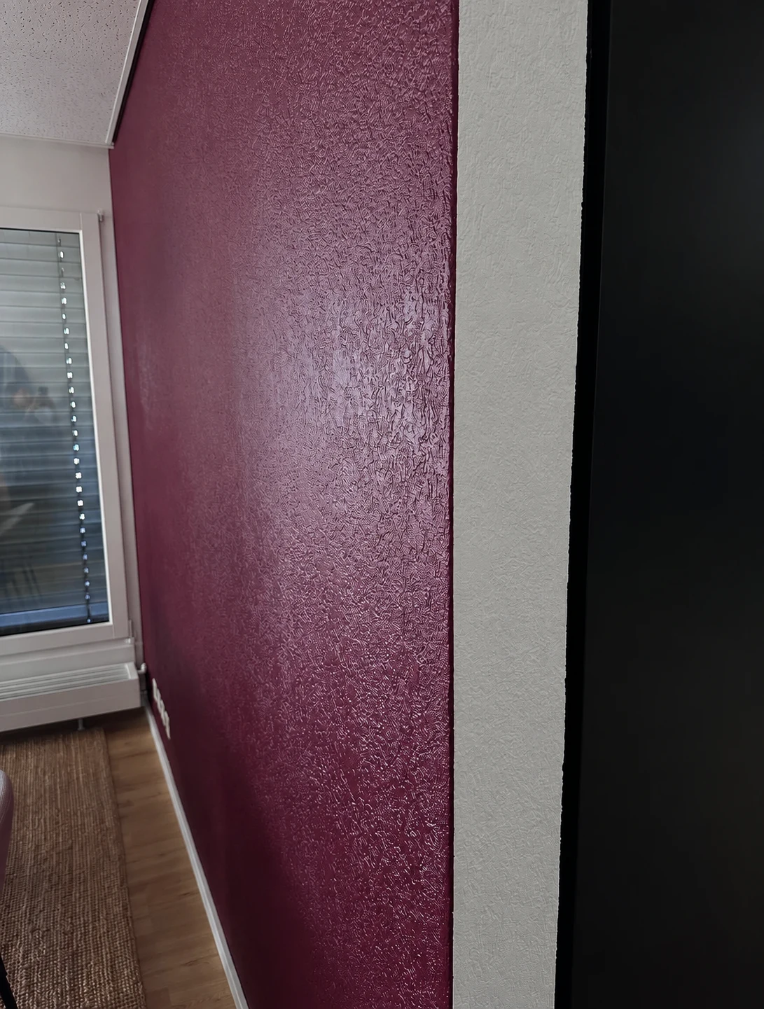 Détail de la texture bordeaux et de la jonction avec un mur blanc