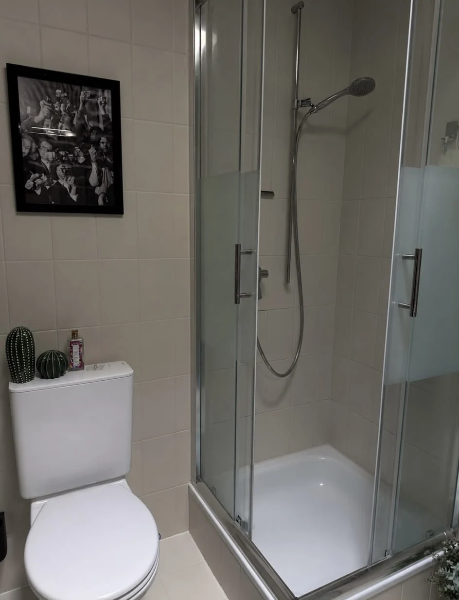 Cabine de douche vitrée et surfaces claires dans une salle de bains